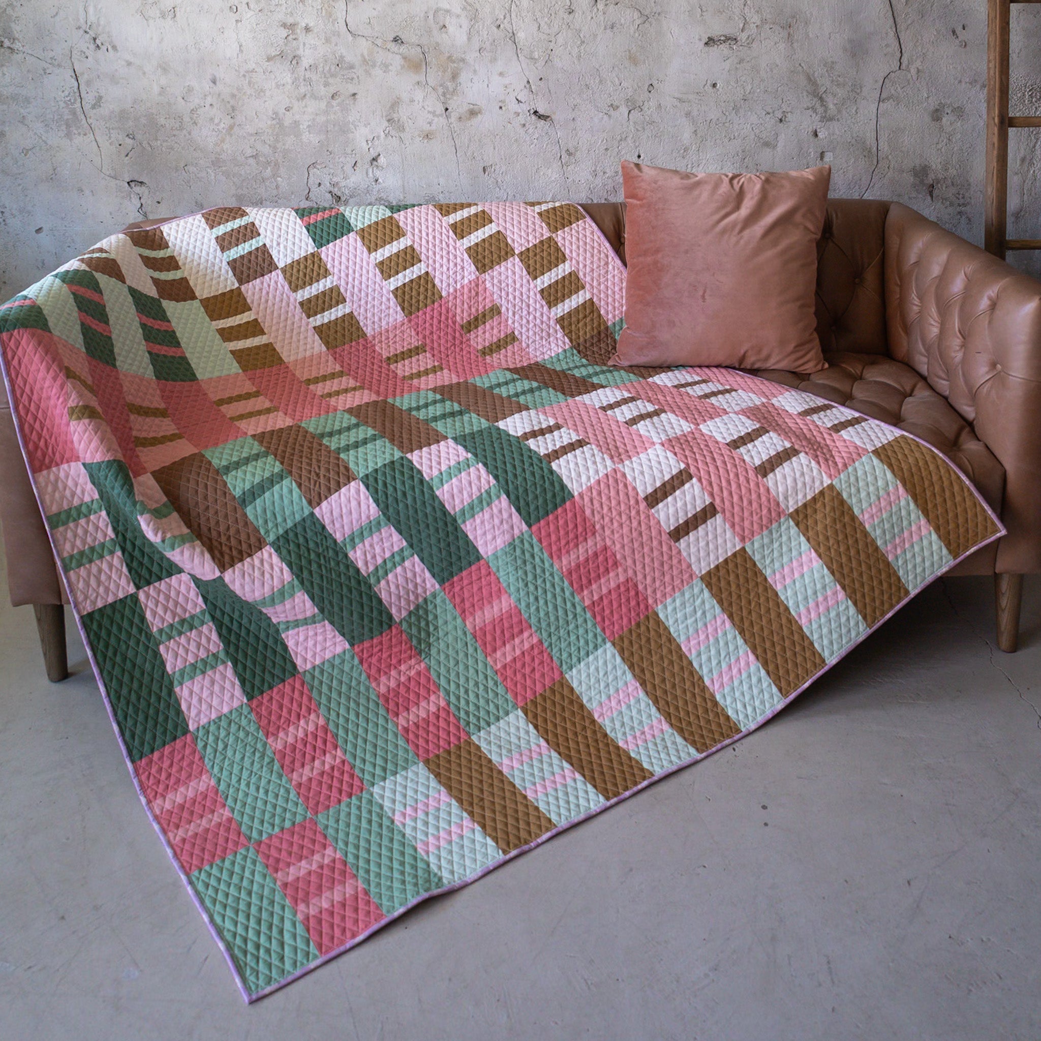 Clover Ruby Sue quilt laid out on a brown couch
