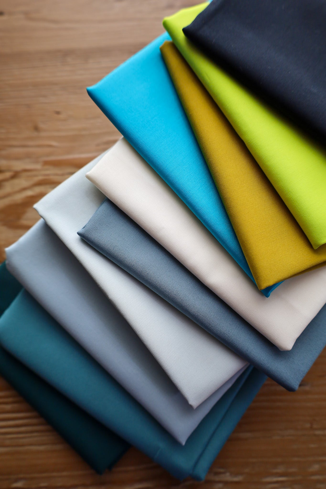 Fabric for Petite Plaid Wintergreen quilt kit on a table
