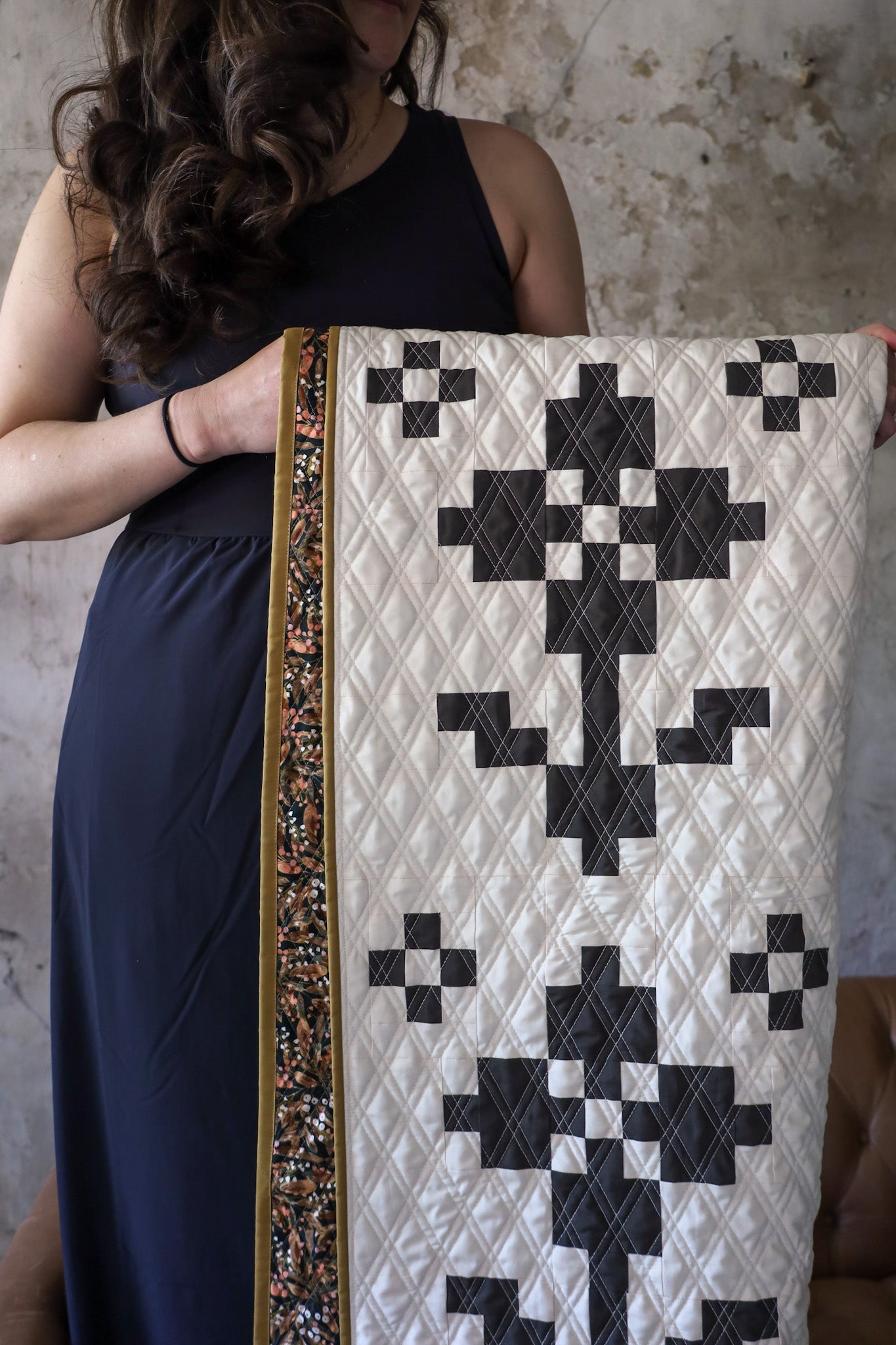 Brittany holding Pansy Patch Lava Rock sample quilt 